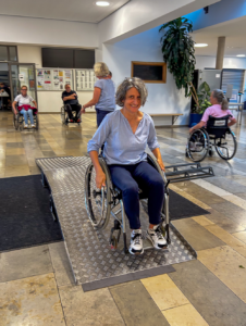 Andrea Janshen fährt mit dem Rollstuhl über eine Rampe aus Metall. 