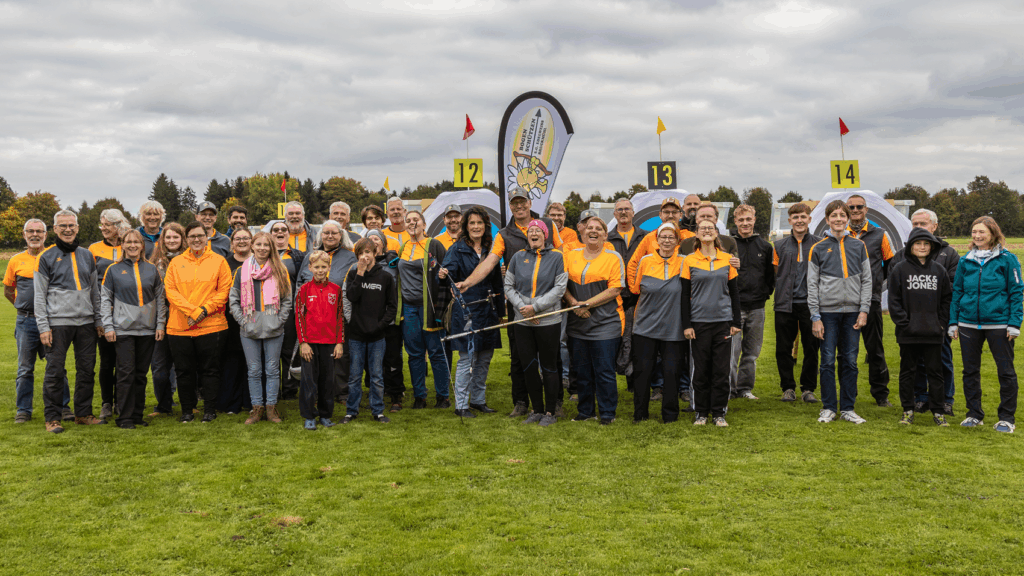 Gruppenfoto von fröhlichen Menschen auf einer Wiese