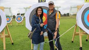 Doris Räder mit Christian Hörberg auf einer Wiese mit Zielen zum Bogenschießen.