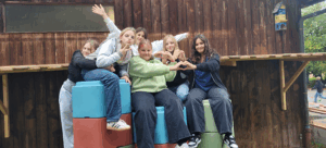 Sechs Schüler der APS sitzen auf den neuen Sitzmöbeln im Freien.