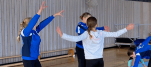Fünf junge Mädchen turnen zusammen.
