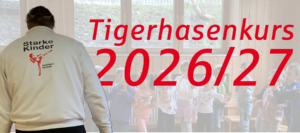 Headergrafik für einen „Tigerhasenkurs 2026/27“: In einem hellen Raum steht ein Trainer mit dem Rücken zur Kamera vor einer Gruppe von Kindern. Auf seiner Jacke steht „Starke Kinder“ mit einem Motiv aus dem Kampfsport. Im Vordergrund ist groß und rot der Schriftzug „Tigerhasenkurs 2026/27“ zu sehen.